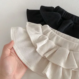 Toddler girls waffle knit flare pants detail shot, cute ruffles fake two-piece skort design.