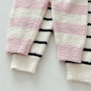 Gros plan detail de pantalon de pyjama bebe doux et duveteux raye, texture chaude.