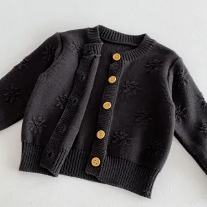 Detailansicht einer dunkelgrauen Baby Strickjacke mit niedlichem Blumenmuster und Holzknöpfen.