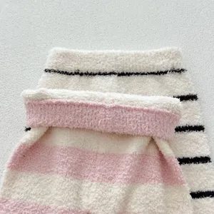 Gros plan sur le tissu doux et pelucheux de pyjama pour bébé à rayures, confortable et chaud.