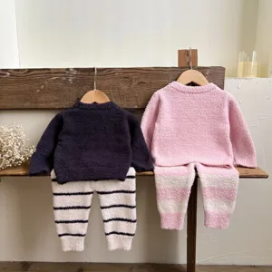 Détail d'ensemble de pyjama duveteux pour enfants, vêtement chaud sur support en bois.