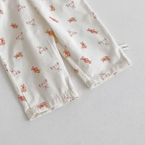 Dettaglio pantaloni neonato cotone stampa orsetto, tessuto twill morbido giornaliero.