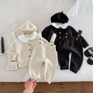 Detailansicht des Strickjacken- und Hosenträgersets für Babys mit süßem Blumenmuster und Hüten.