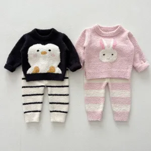 Détail de pyjama bébé doux et duveteux avec motifs mignons de pingouin et lapin.