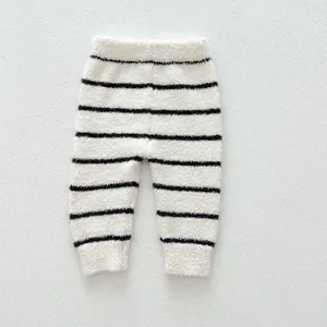 Gros plan détaillé du pantalon de détente douillet pour bébé en peluche douce et rayures.