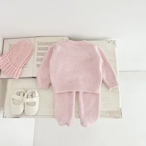 Cute baby winter plush pajama set detail, soft pink fleece sleepwear with hat and shoes.