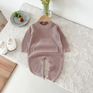 Vista detallada del tierno pelele de punto para bebé en color rosa con práctico bolsillo.