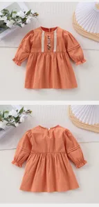 Vue détaillée de la jolie robe orange pour petite fille avec broderie florale et jolis volants.