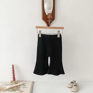 Detail view of black knitted flared pants for baby girls, soft texture and minimalist design.