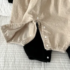 Nahaufnahme eines Baby Cord Stramplers mit praktischem Druckknopfverschluss und Stofftextur.