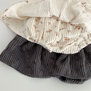 Infant floral corduroy romper detail, soft fabric texture, cute baby girl spring style.