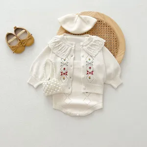 Vue détaillée de l'ensemble gilet bébé tricoté avec broderie florale et sac en perles.