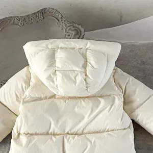 Detalle chaqueta de plumón blanca para bebé, mameluco con capucha cálido, acolchado.