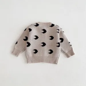 Infant baby knitted cardigan back detail, beige cotton knit with black moon print pattern.