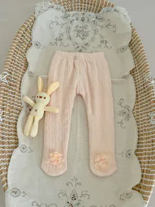 Detailed view of pink baby fleece-lined footed tights with cute ankle floral decoration.