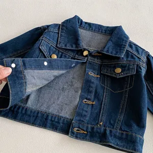 Primo piano dettagliato della giacca di jeans blu per bambini bottoni a pressione.