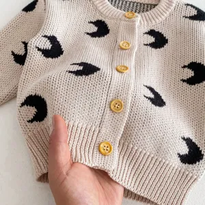 Infant baby knit cardigan detail view, cute all-over moon print with wood buttons cozy top.