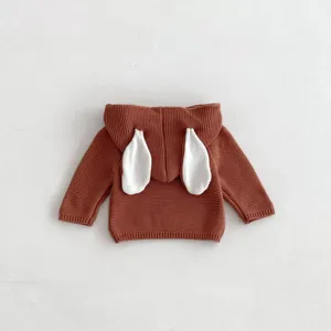 Detail view of cute baby knit sweater featuring soft brown fabric and playful white bunny ears.