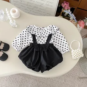 Cute baby girl autumn outfit set, long sleeve heart print blouse and black suspender shorts.