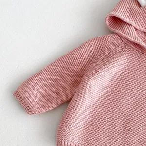 Close-up of cute baby pink knitted hooded sweater detail with lovely rabbit ears design.