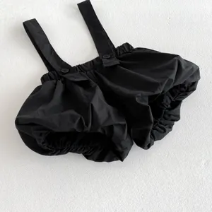 Baby black suspender bloomers detail view, featuring elastic waist and cute button straps.