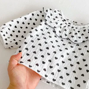 Detailed view of cute baby girl white long sleeve shirt with black heart print doll collar