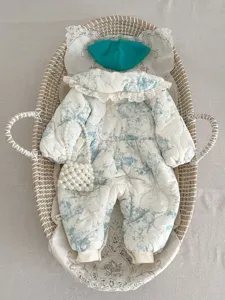 Detailed view of baby winter quilted jumpsuit featuring classic toile print, ruffles, and warm padding.
