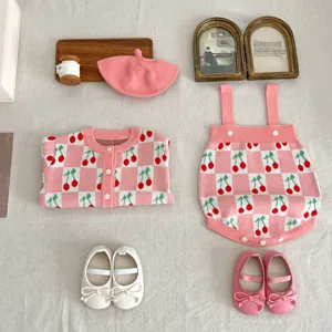 Cute baby girl knitwear set with pink checkered cherry cardigan, romper, beret and cute shoes.