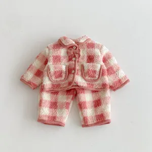 Girls winter fleece lined plaid pajama set detail view, pink checkered lounge wear top and pants.