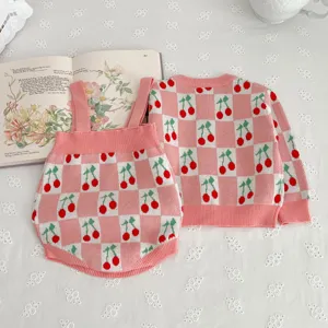 Cute baby knit sweater set featuring pink checkerboard and cherry jacquard pattern details.