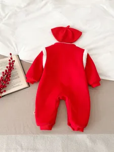 Vista dettagliata della tutina rossa in velluto per neonati con cappellino coordinato, stile festivo.
