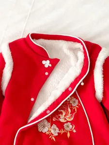 Vista dettagliata della tutina in pile rossa per bambina, in stile tradizionale cinese.