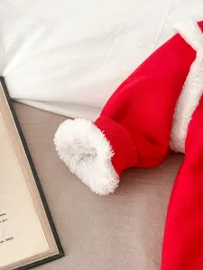Dettaglio tutina invernale in pile rosso per neonato, manica in morbido peluche, moda bebè.