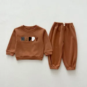 Toddler brown sweatshirt and pants detail showing soft fabric texture and cute embroidered letter design.