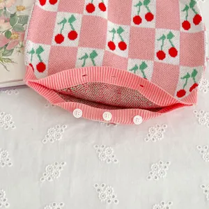Baby knit romper detail, pink and white checkerboard with cute cherry jacquard pattern.