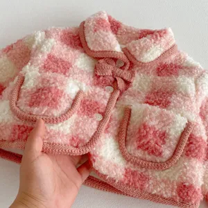 Cute pink and white plaid fleece jacket detail, showing soft fluffy texture and buttons.