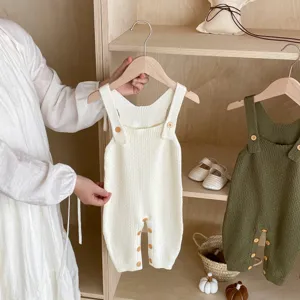 Detailed view of the baby knit romper displayed on a wooden shelf, soft and cozy texture.