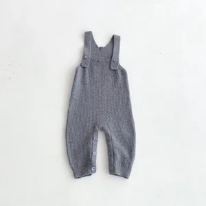 Knit baby romper detail shot, grey color, comfortable suspender design with buttons.
