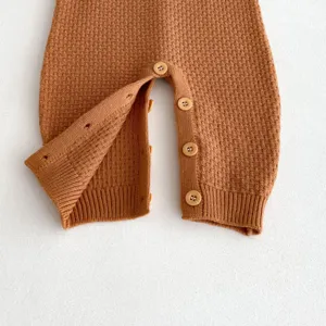 Cute baby knitted romper detail shot, comfortable infant waffle knit crawler with buttons.