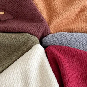 Detailed view of soft knitted baby clothing fabric swatches in vibrant multiple color options.
