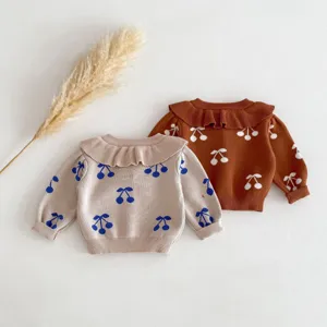 Detailed view of toddler girls knit sweater featuring cute cherry pattern and elegant ruffled collar.