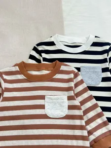 Detalle de primer plano de mameluco de bebé a rayas de manga larga con bolsillo frontal.