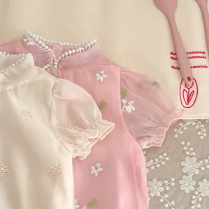 Close up of cute baby girl summer short sleeve cheongsam romper with floral embroidery details.