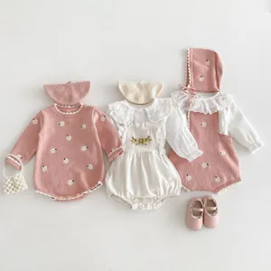 Vista dettagliata del set romper per neonata in maglia con ricamo margherite e cuffietta.