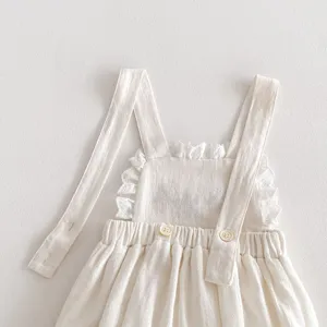 Dettaglio tutina in cotone per neonata bambina, design con spalline con volant graziosi