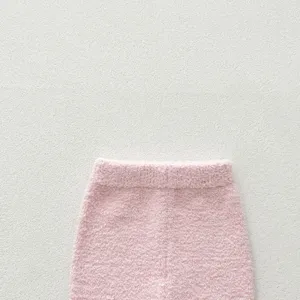 Pink plush baby pajama pants detail, soft cozy fuzzy winter infant sleepwear bottom part.
