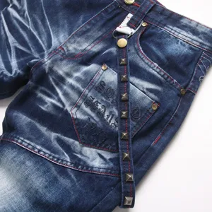 Details van vintage gewassen heren jeans, met punk klinknagels, rode stiksels en zakborduurwerk.