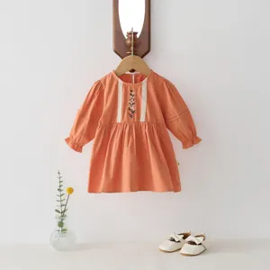 Robe orange à manches longues pour petite fille avec bordure en dentelle et broderie.