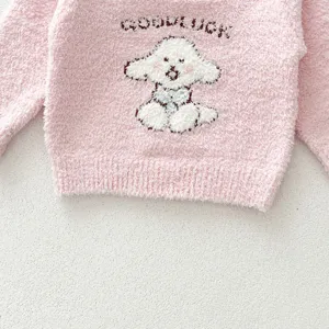 Cute baby pink fluffy sweater detail featuring a lovely knitted puppy and woven goodluck text.