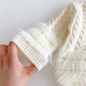 Infant baby knit sweater detail, white cable knit fabric with soft plush trim on cuff.